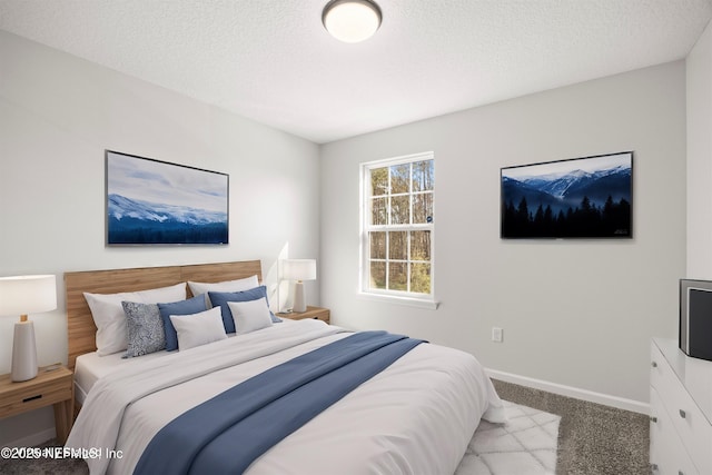 carpeted bedroom featuring a textured ceiling and baseboards