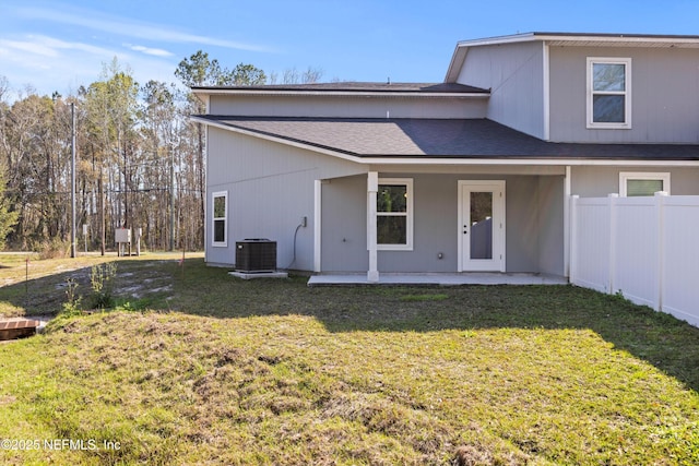 back of property featuring a patio, a shingled roof, a lawn, fence, and cooling unit