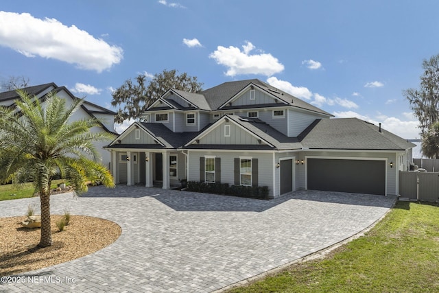 view of front of house with board and batten siding, decorative driveway, and a garage