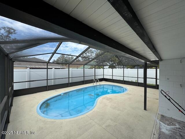 view of swimming pool with glass enclosure and a patio area