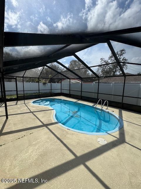 view of pool with a lanai and a patio