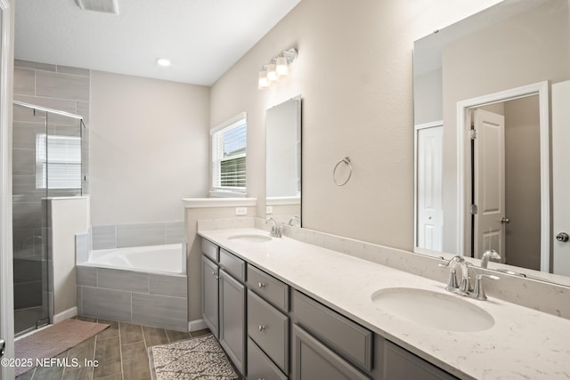 bathroom featuring separate shower and tub and vanity