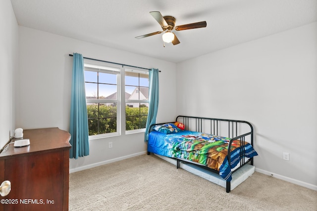 carpeted bedroom featuring baseboards and a ceiling fan