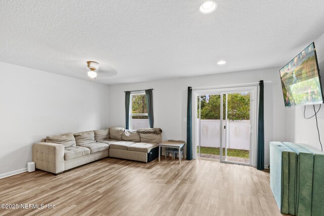living room with light wood-style floors, radiator, recessed lighting, and a textured ceiling