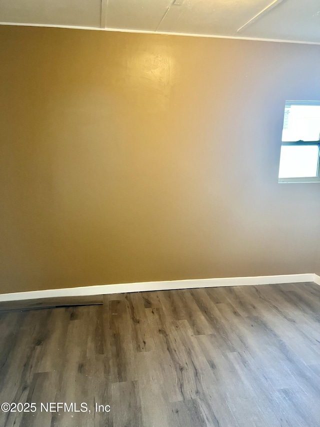 unfurnished room with wood finished floors and baseboards