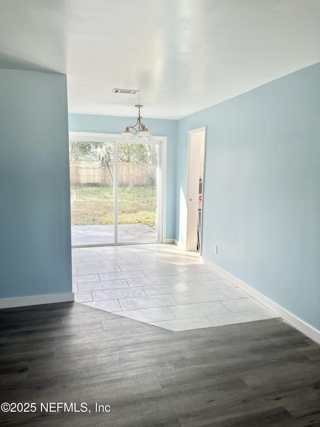 unfurnished living room featuring visible vents, baseboards, and wood finished floors