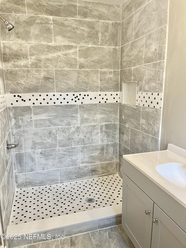 bathroom featuring vanity and tiled shower