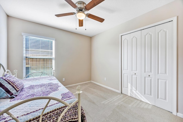 bedroom featuring light colored carpet, a closet, and ceiling fan