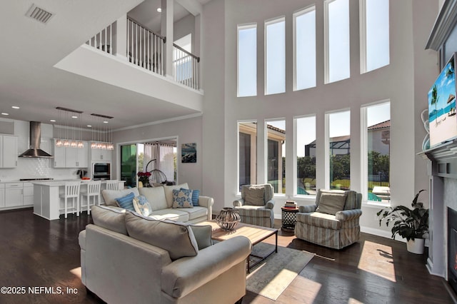 living room featuring ornamental molding and dark wood-type flooring