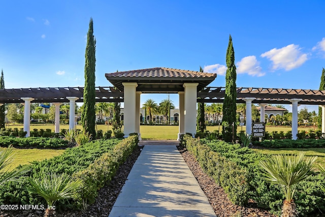 view of property's community with a yard and a pergola