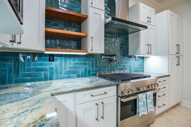 kitchen featuring stainless steel range with gas stovetop, backsplash, light stone counters, white cabinets, and wall chimney exhaust hood