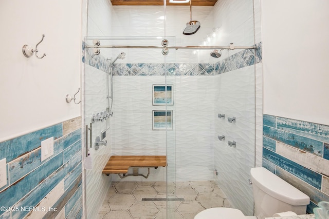 bathroom featuring tile walls, toilet, and walk in shower