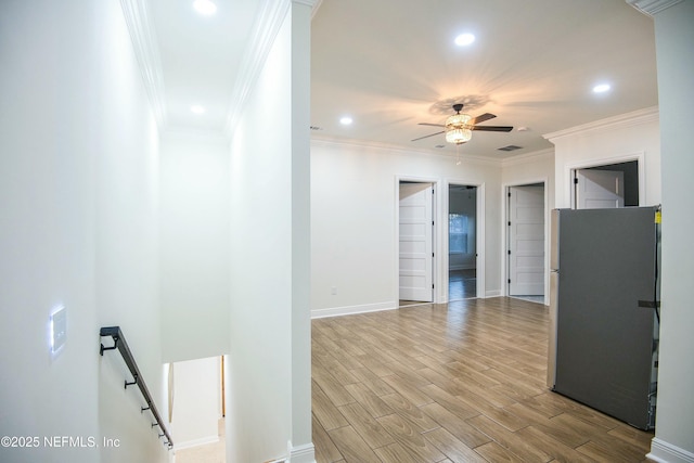 hallway featuring ornamental molding and light hardwood / wood-style floors