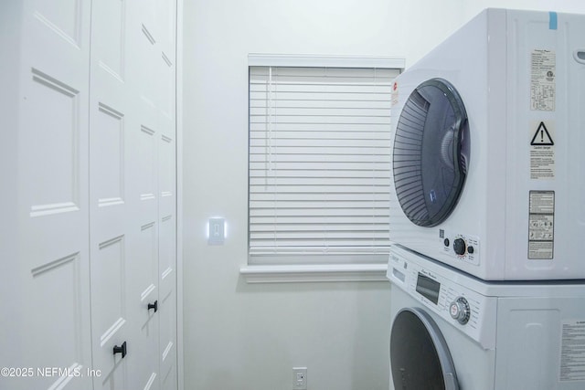 clothes washing area with stacked washer and clothes dryer