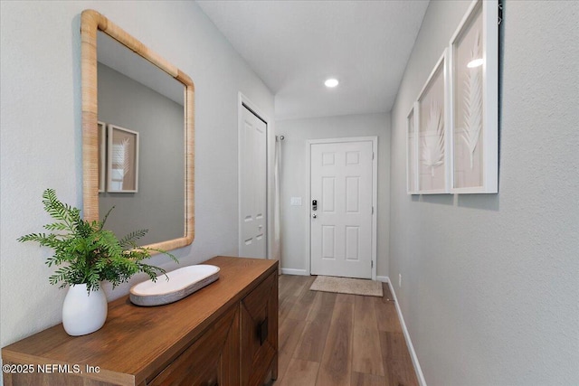 doorway to outside with dark wood finished floors, recessed lighting, and baseboards