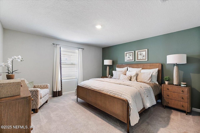 bedroom featuring light colored carpet, a textured ceiling, and baseboards