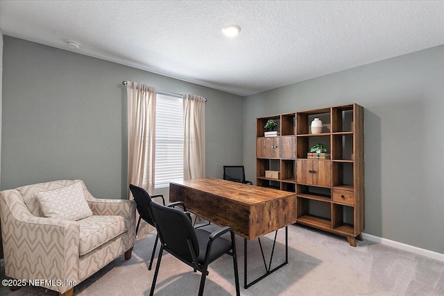 office area featuring light carpet, a textured ceiling, and baseboards