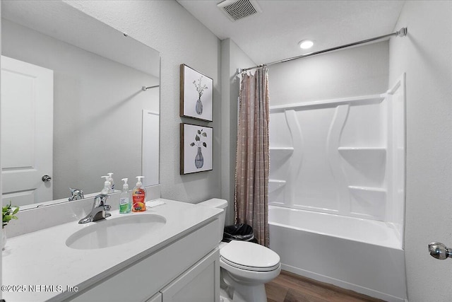 full bath featuring vanity, wood finished floors, visible vents, shower / tub combo, and toilet