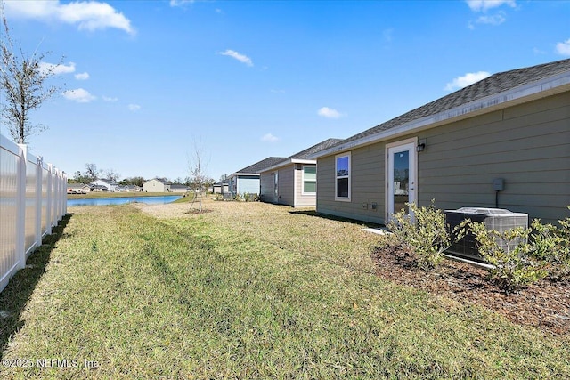 view of yard featuring central air condition unit and a water view