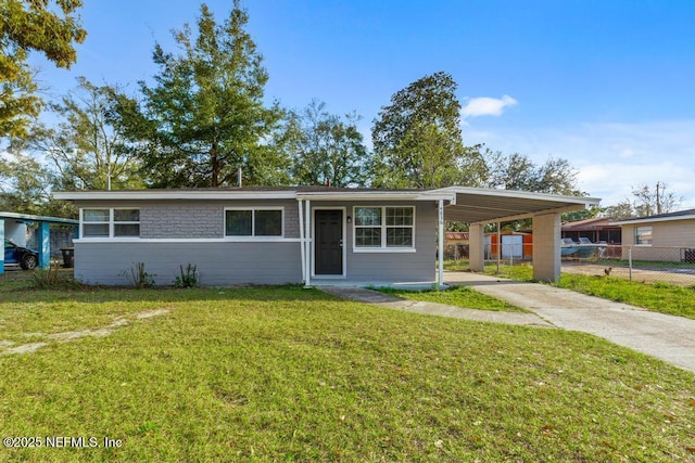 ranch-style home featuring a carport and a front yard