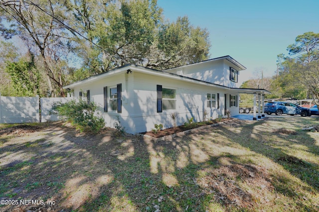 view of property exterior featuring a patio and fence