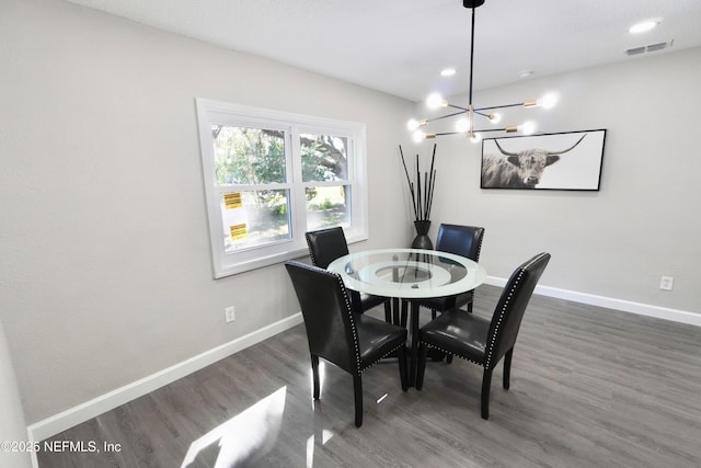 dining area featuring visible vents, baseboards, dark wood finished floors, and a notable chandelier