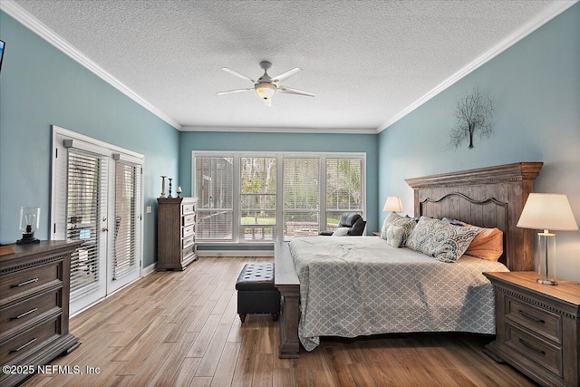 bedroom featuring ornamental molding, light wood finished floors, a textured ceiling, and access to exterior