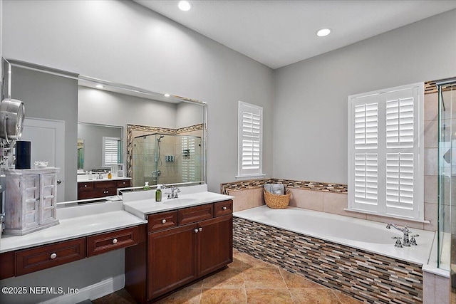 bathroom with a stall shower, recessed lighting, a bath, and vanity