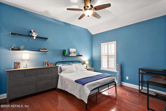 bedroom with baseboards, a ceiling fan, lofted ceiling, dark wood-style flooring, and a textured ceiling