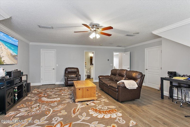 living area with crown molding, a textured ceiling, and wood finished floors