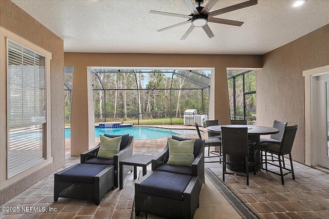 sunroom with ceiling fan and a swimming pool