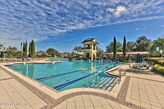 pool featuring a patio and a water slide