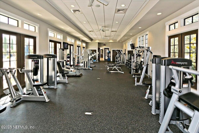 gym featuring a tray ceiling, french doors, visible vents, and a drop ceiling