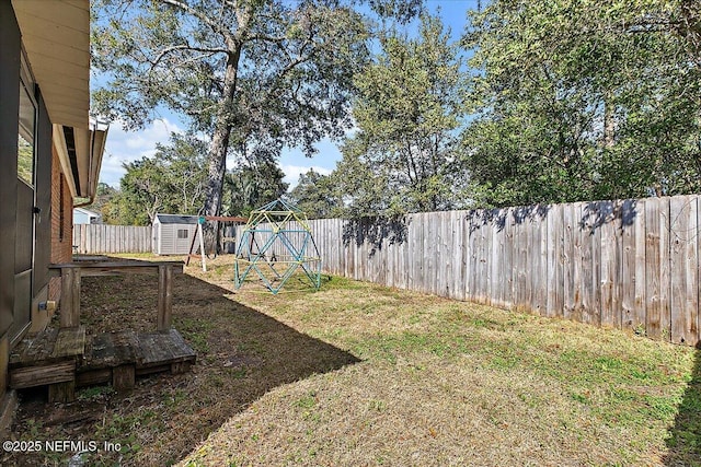 view of yard featuring a fenced backyard, an outdoor structure, and a storage unit