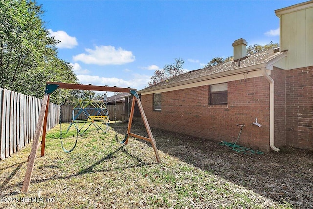 view of yard featuring a playground and a fenced backyard