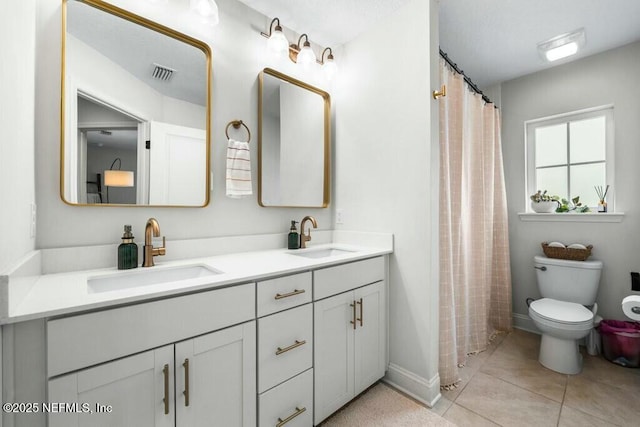 bathroom featuring tile patterned flooring, visible vents, a sink, and double vanity