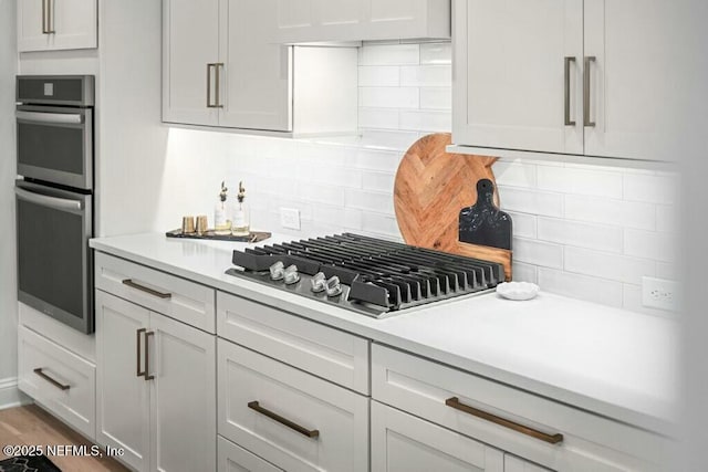 kitchen with stainless steel appliances, white cabinetry, and light countertops