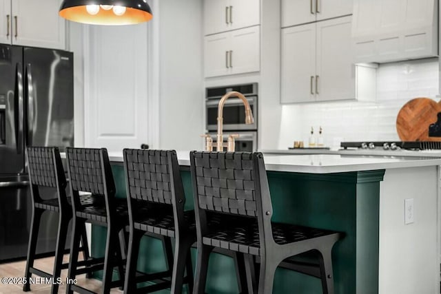 kitchen with light countertops, a kitchen bar, and white cabinetry