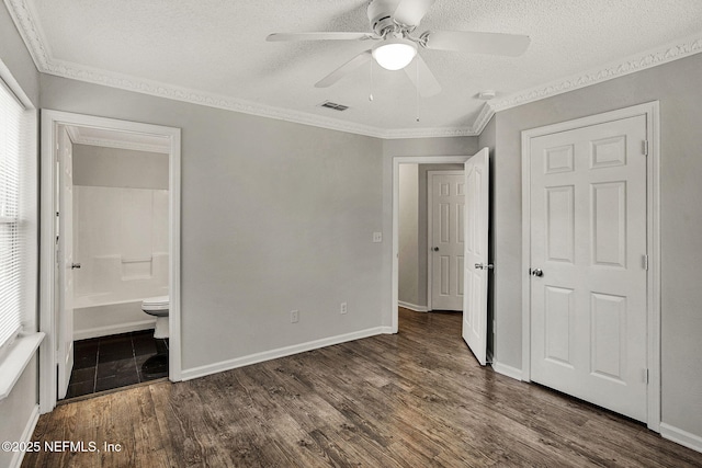 unfurnished bedroom featuring a textured ceiling, crown molding, and dark hardwood / wood-style floors