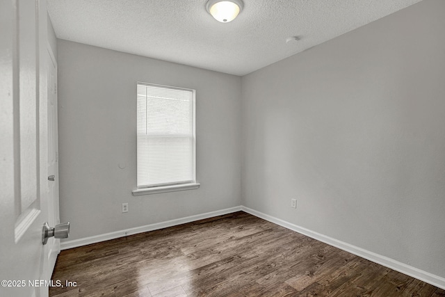 unfurnished room with a textured ceiling and dark hardwood / wood-style floors