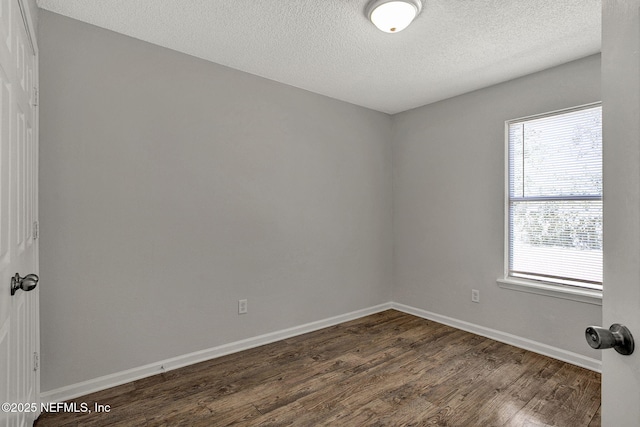 unfurnished room featuring a textured ceiling and dark hardwood / wood-style flooring