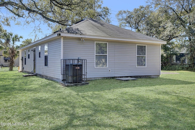 view of side of home featuring central air condition unit and a lawn