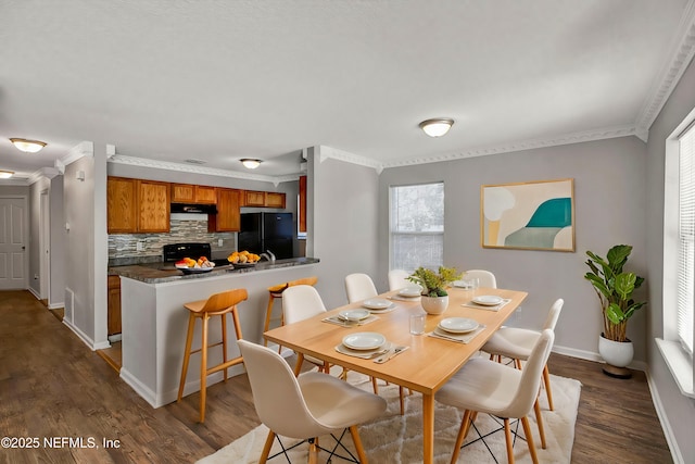 dining room featuring ornamental molding and dark hardwood / wood-style flooring