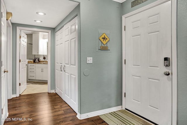 foyer featuring baseboards and dark wood finished floors