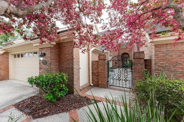 view of front facade featuring a garage, a gate, and brick siding