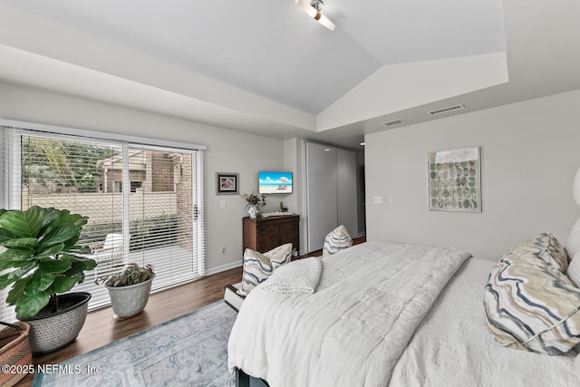 bedroom with lofted ceiling, wood finished floors, visible vents, access to exterior, and baseboards