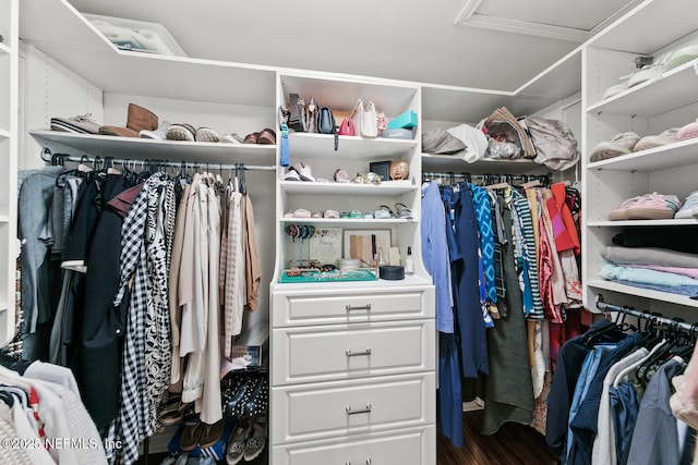 walk in closet with wood finished floors and attic access