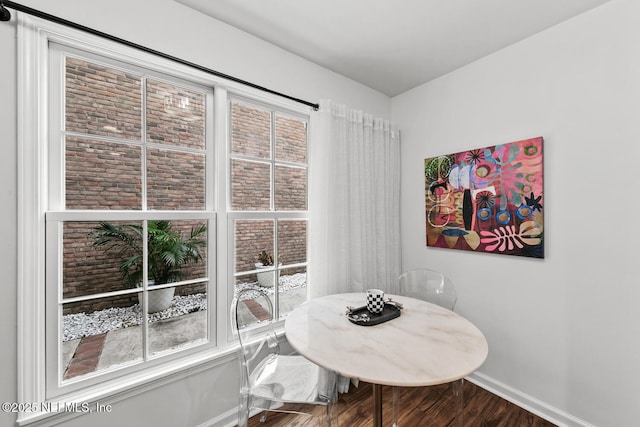 dining space featuring baseboards and wood finished floors