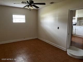 empty room featuring wood finished floors, a ceiling fan, and baseboards