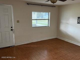 empty room with baseboards and a ceiling fan